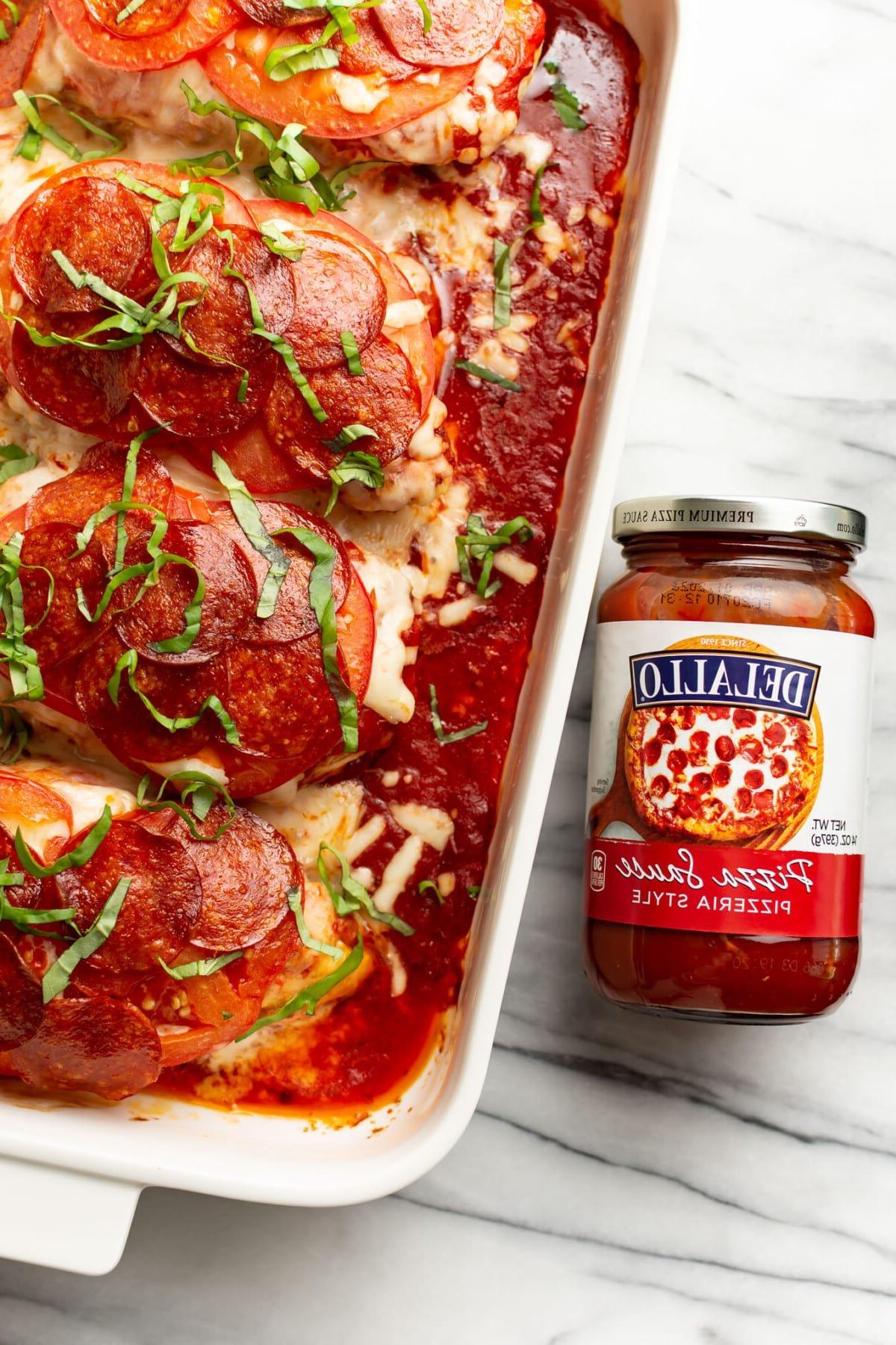 Pizza Hähnchen 7 Eine Auflaufform mit fertig gebackenem Pizza-Hähnchen, daneben ein Glas DeLallo Pizzasauce