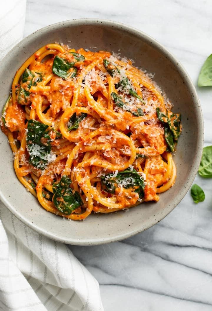 Cremige Pasta mit gerösteter roter Paprika 8 Eine Schale gerösteter Paprika Bucatini neben einer Stoffserviette