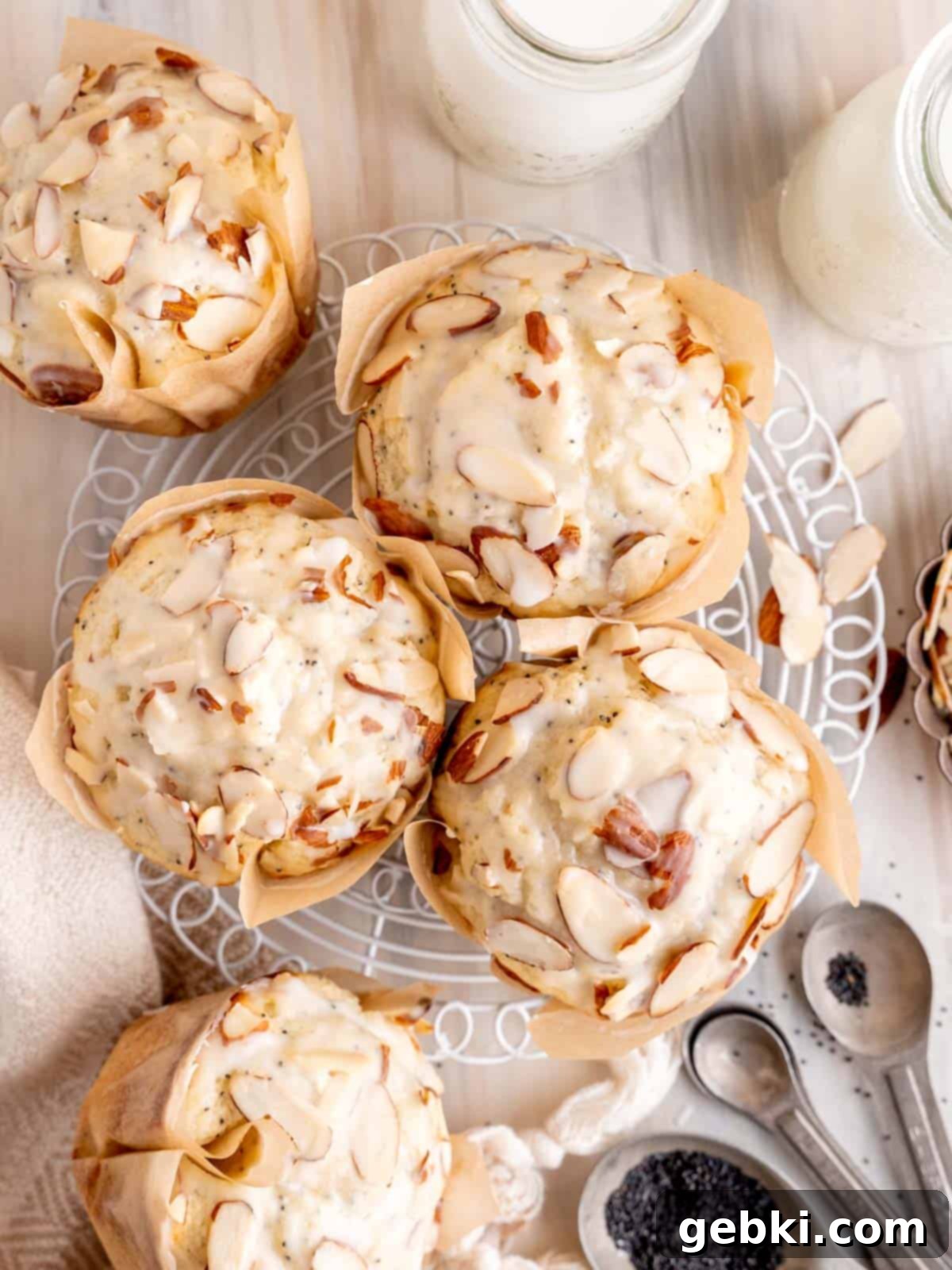 Irresistible Almond Poppy Seed Muffins 2 Top view of glazed almond poppy seed muffins on a cooling rack, showcasing their fluffy tops and almond slivers.