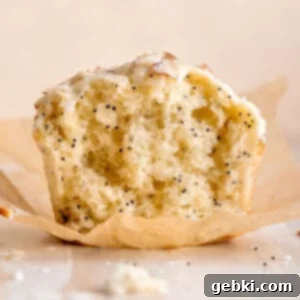 Irresistible Almond Poppy Seed Muffins 8 A freshly baked almond poppy seed muffin with glaze and almonds on top.