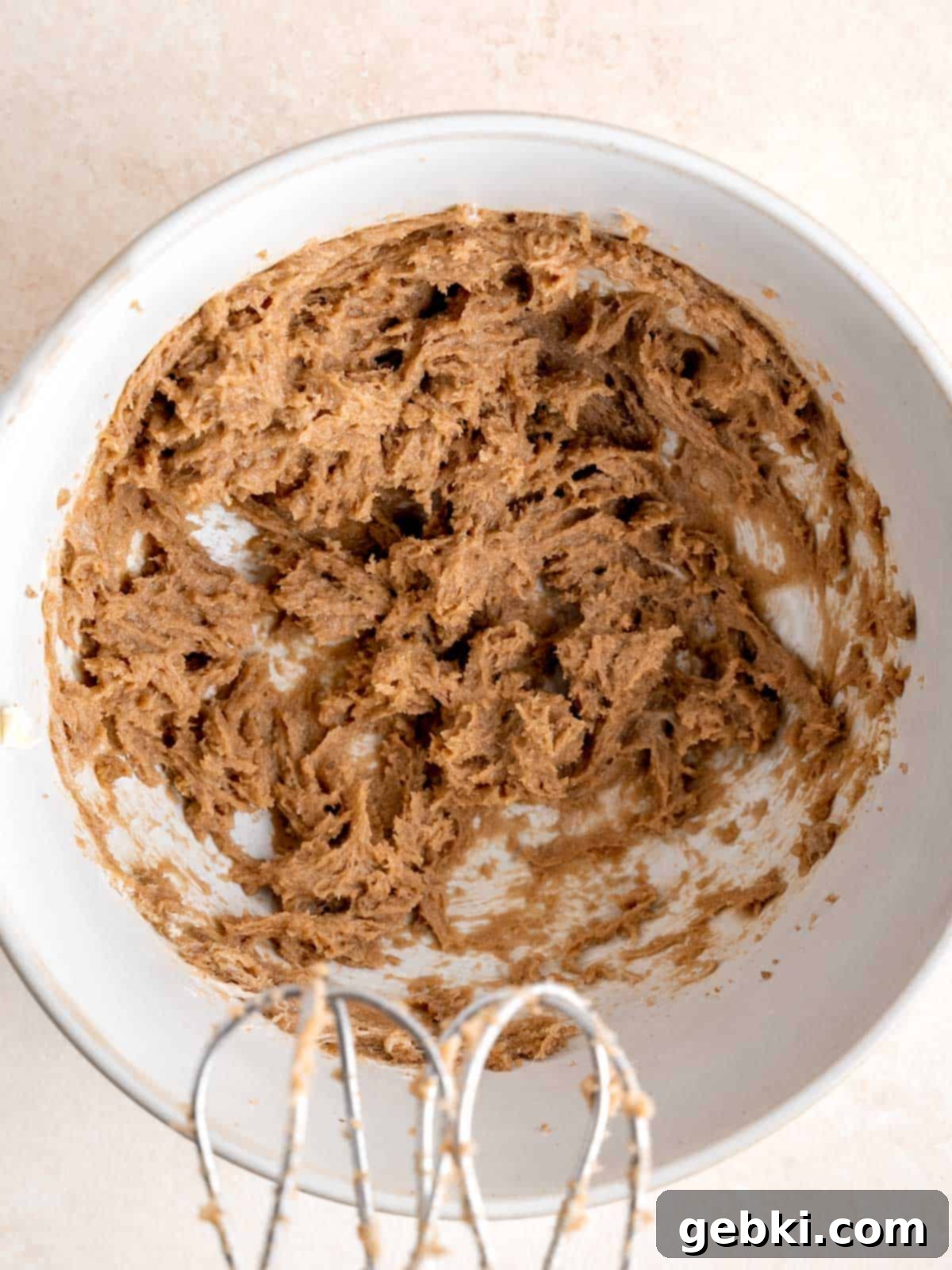 Softened butter and brown sugar mixed in a bowl with a hand mixer.