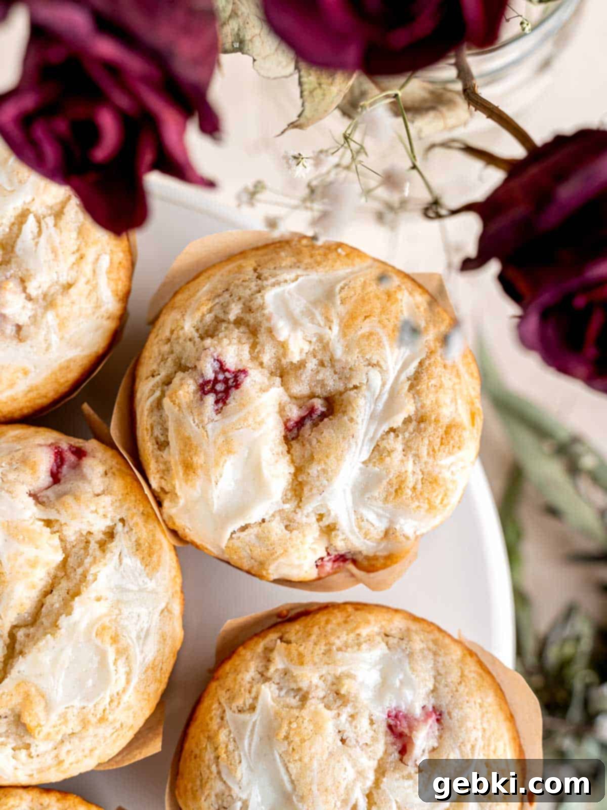 Luscious Strawberry Cream Cheese Muffins 2 Strawberry muffins with cream cheese swirls on top, showcasing their delightful appearance.