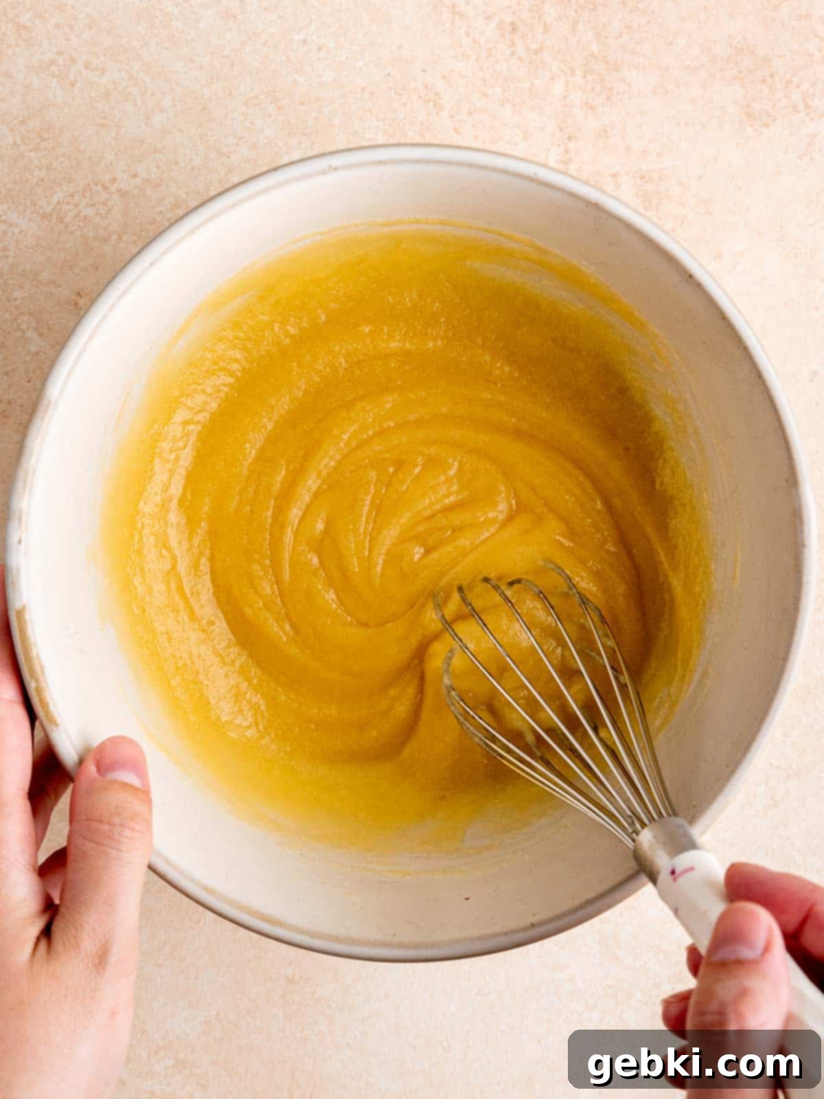 White Chocolate Raspberry Swirl Blondies 4 A bowl with granulated sugar, melted butter, room temperature egg, and vanilla extract being whisked together until smooth and well combined.