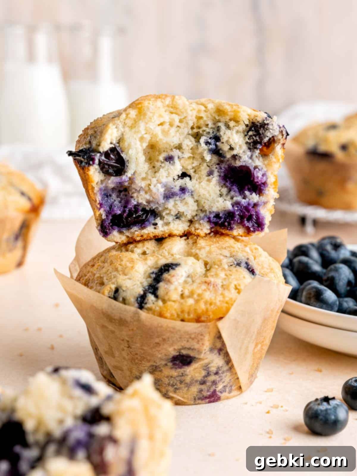 Ultimate Sourdough Discard Blueberry Muffins 2 Half of a jumbo blueberry muffin stacked on a whole one.