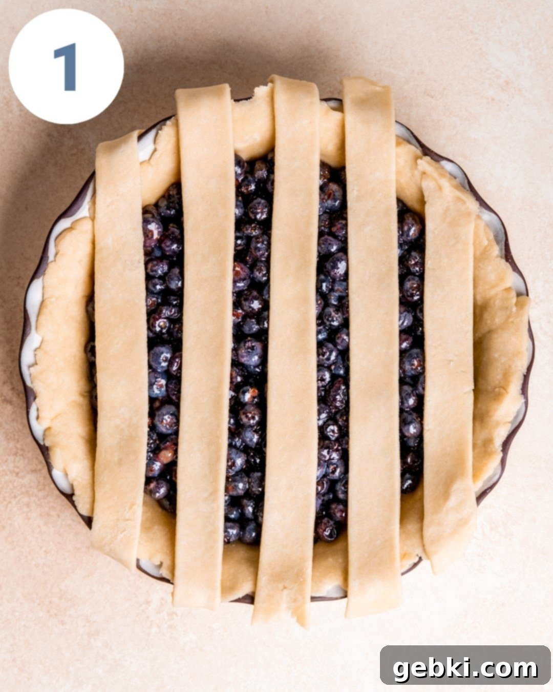 Aromatic Blueberry Delight 6 The first five strips of pie dough laid vertically over the blueberry filling.