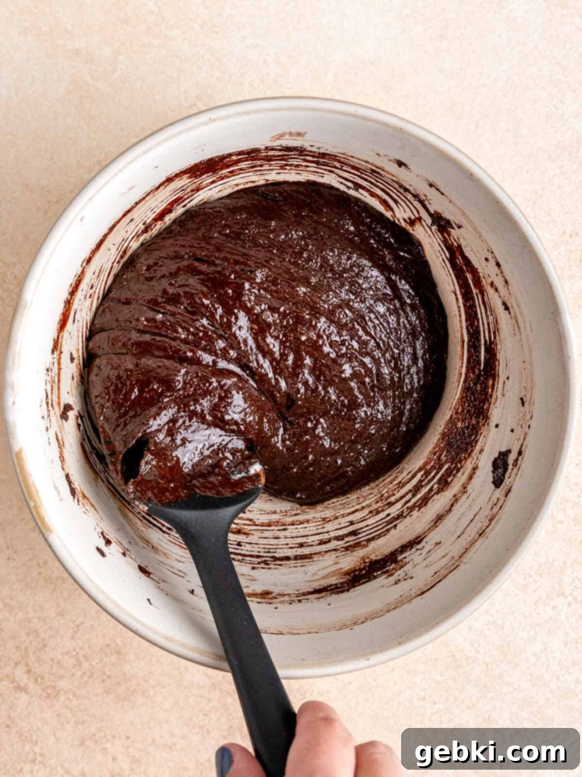 Peanut Butter Cup Brownie Bites 5 Stirring brownie batter in a bowl with a spatula.
