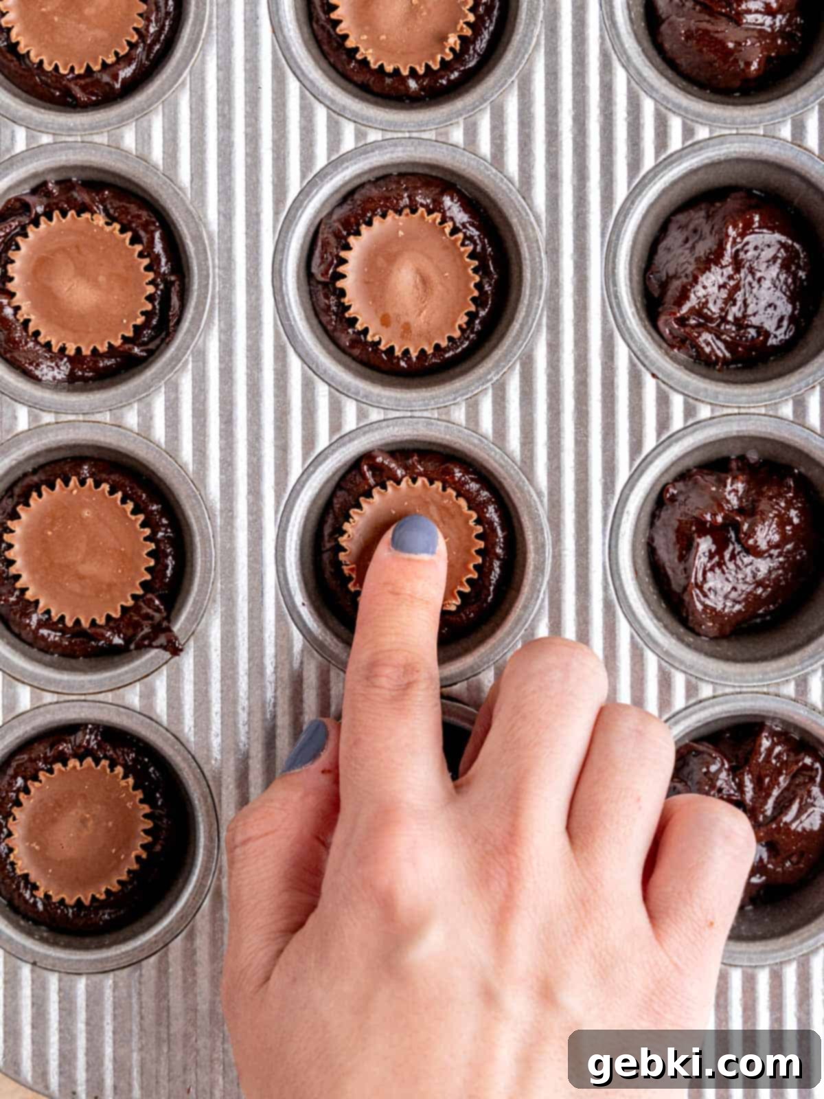 Peanut Butter Cup Brownie Bites 7 Pressing a mini peanut butter cup into brownie batter.