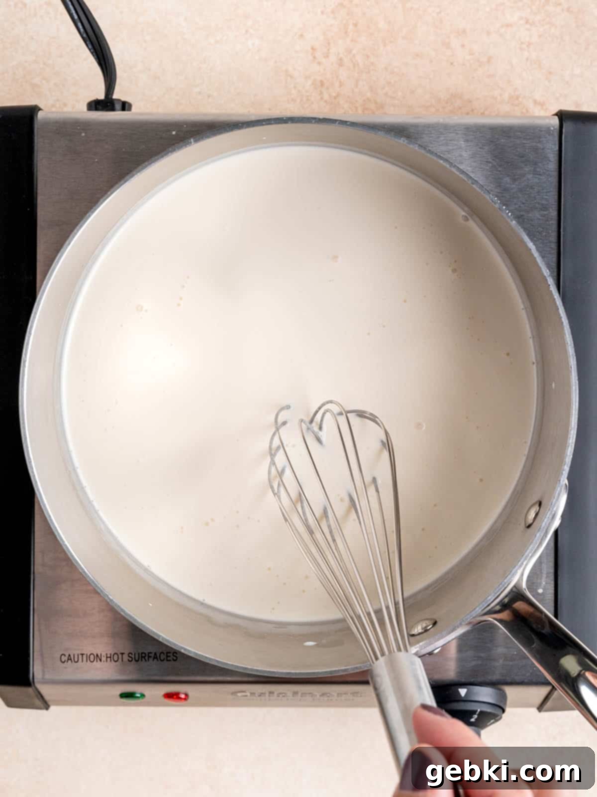Amaretto Cherry Bliss 4 Whisking heavy whipping cream, half and half and almond liqueur in a pot.
