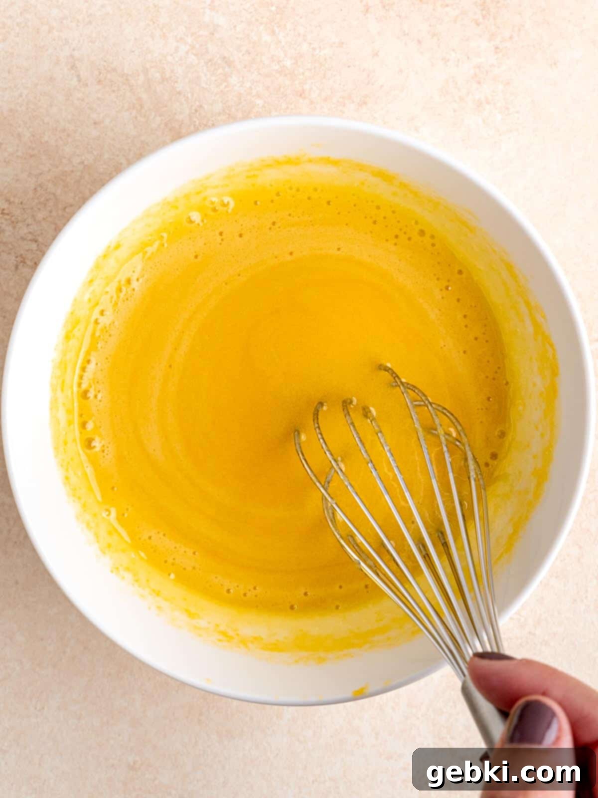 Amaretto Cherry Bliss 5 Whisking tempered egg yolks in a bowl.