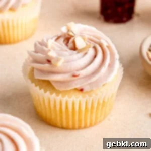 Almond Cupcakes with Raspberry Cream Cheese Frosting decorated with sliced almonds and fresh raspberries.