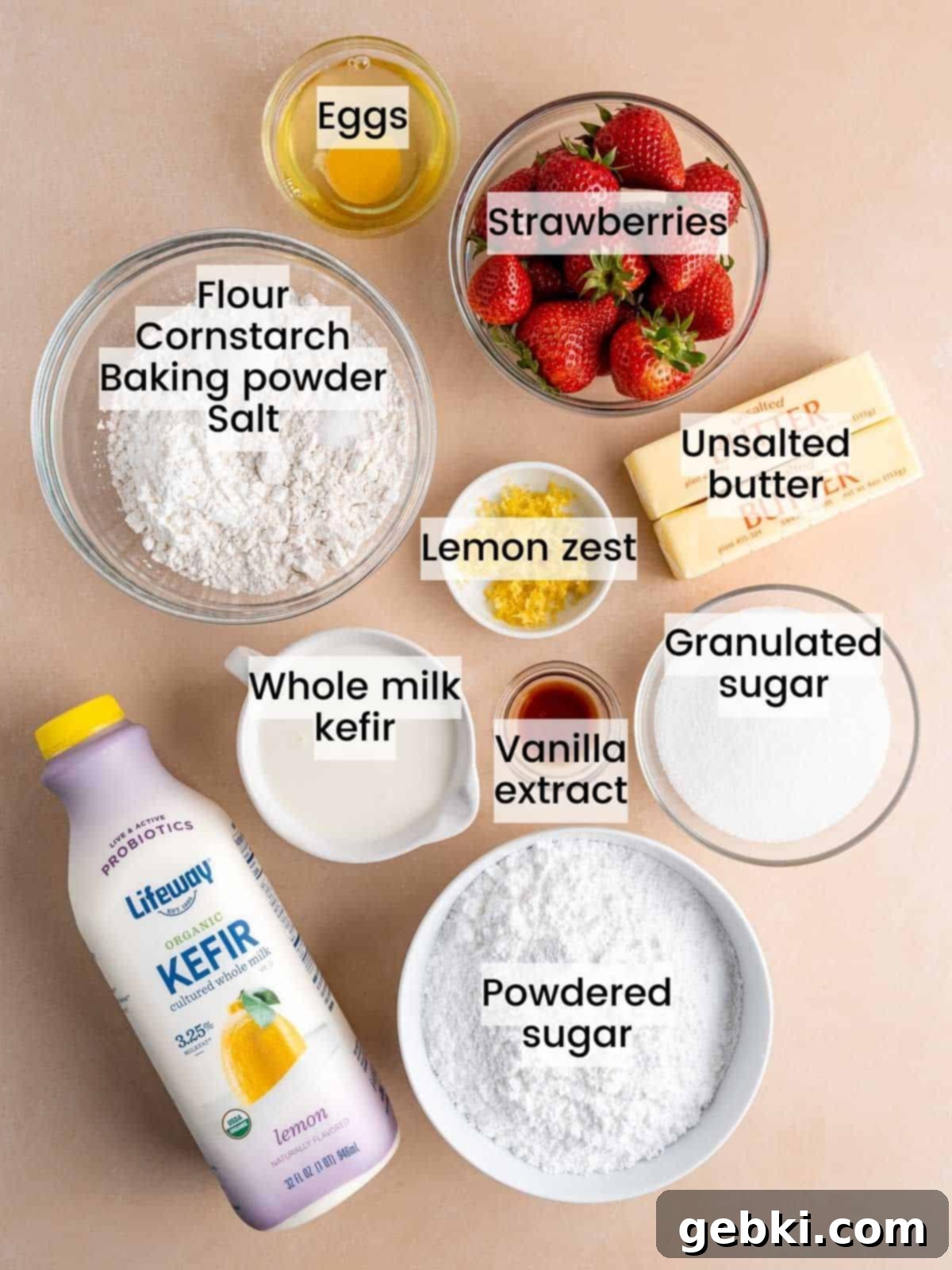 Zesty Lemon Cupcakes with Strawberry Filling 3 Ingredients laid out for making lemon cupcakes with strawberry filling and lemon strawberry buttercream, including lemons, strawberries, butter, and kefir.