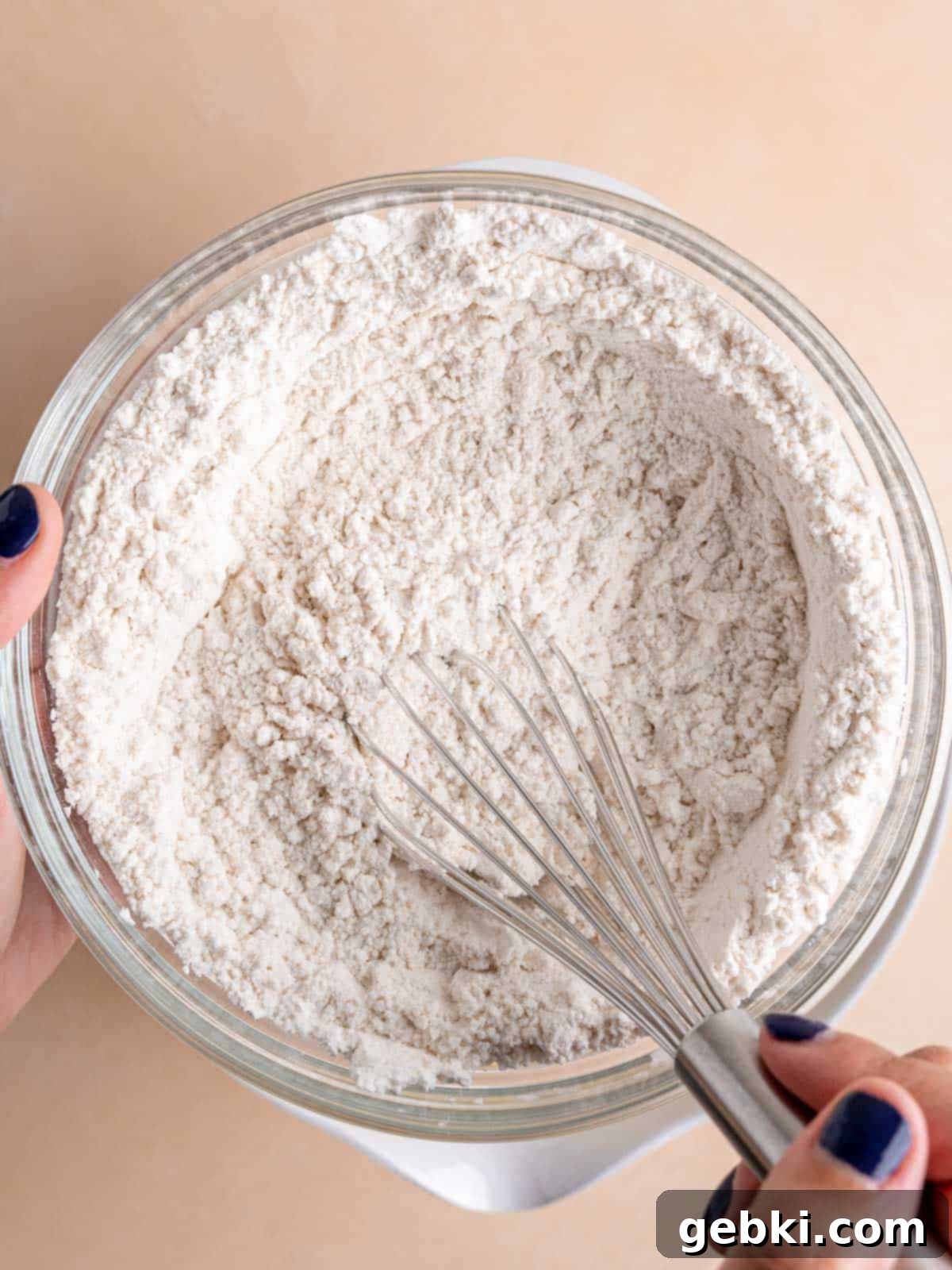 Zesty Lemon Cupcakes with Strawberry Filling 4 Whisking dry cupcake ingredients in a bowl, showing flour, cornstarch, baking powder, and salt combined.