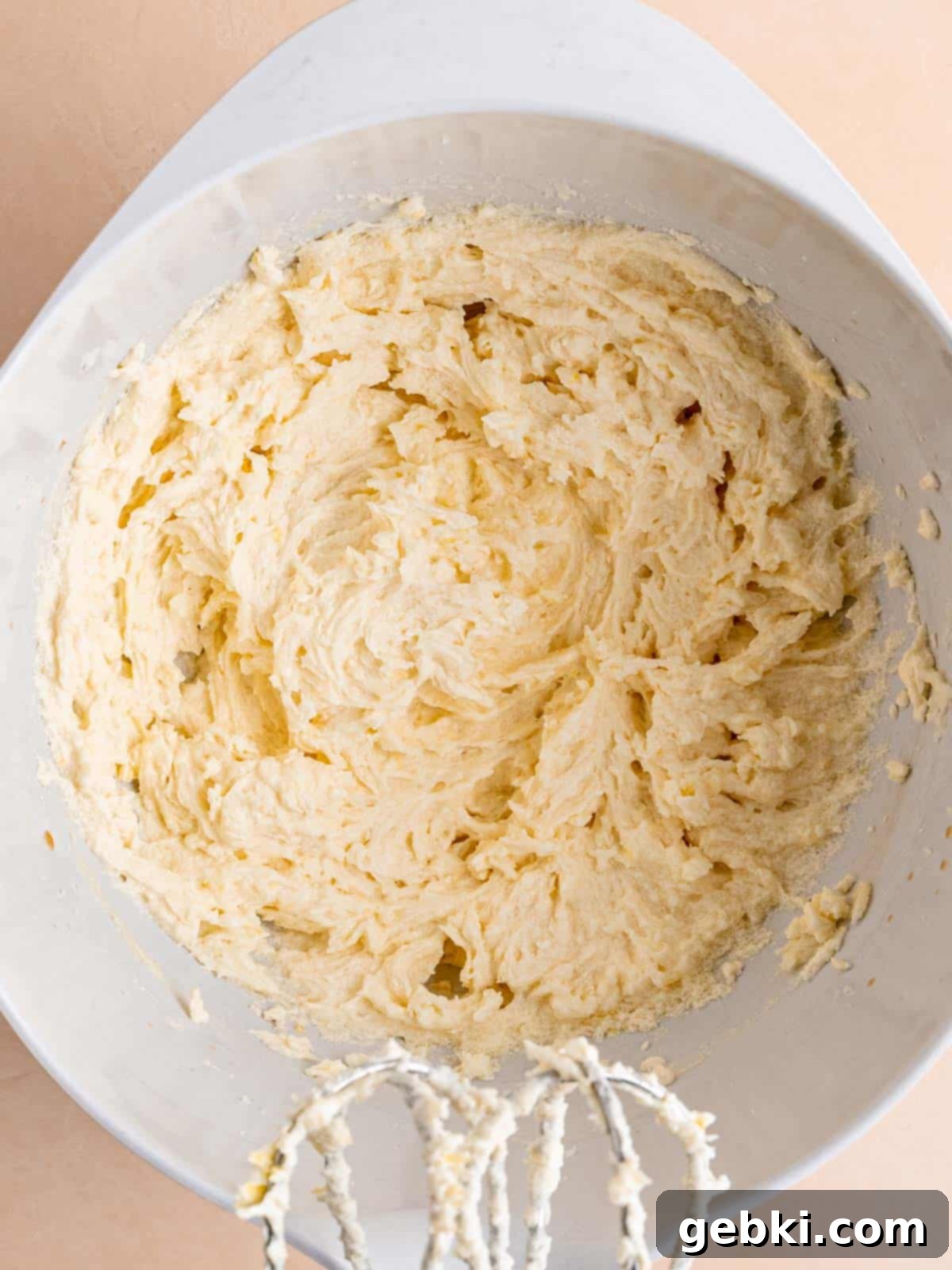 Zesty Lemon Cupcakes with Strawberry Filling 5 Softened butter, granulated sugar, lemon zest, whole egg, egg white, and vanilla extract mixed together in a large bowl, appearing light and fluffy.