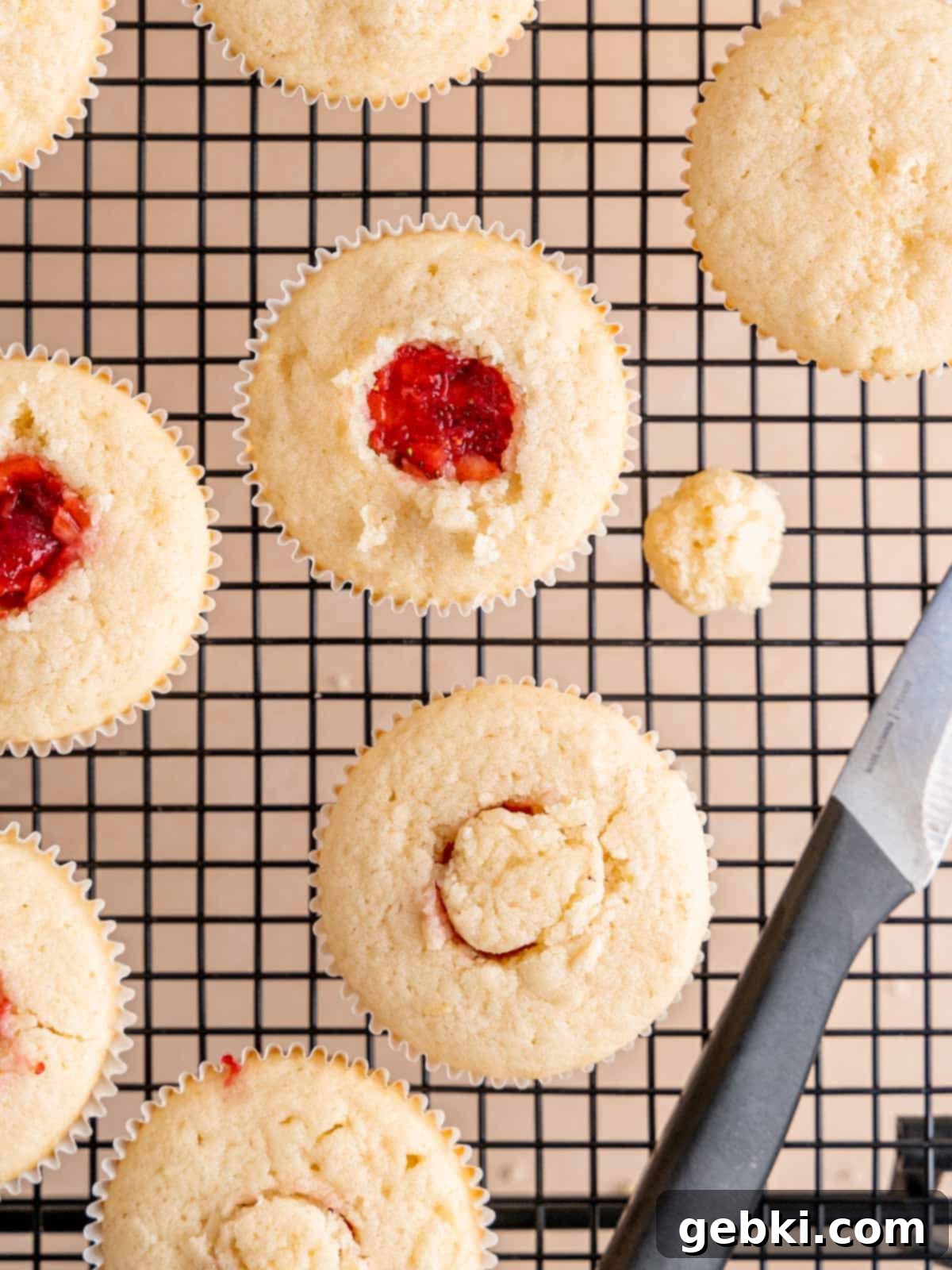 Zesty Lemon Cupcakes with Strawberry Filling 8 Cupcakes with their centers cut out and filled with bright, sweetened fresh strawberries, ready for frosting.