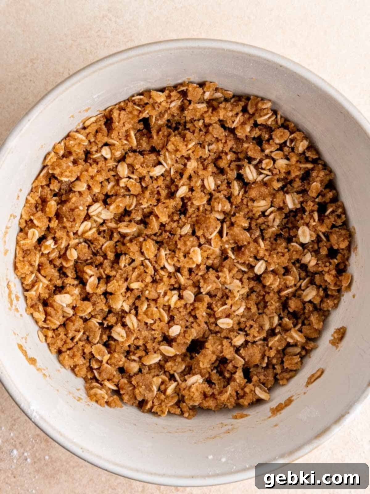 Sweet Summer Blueberry Peach Crisp 4 Cinnamon oat streusel, resembling wet sand, in a mixing bowl.
