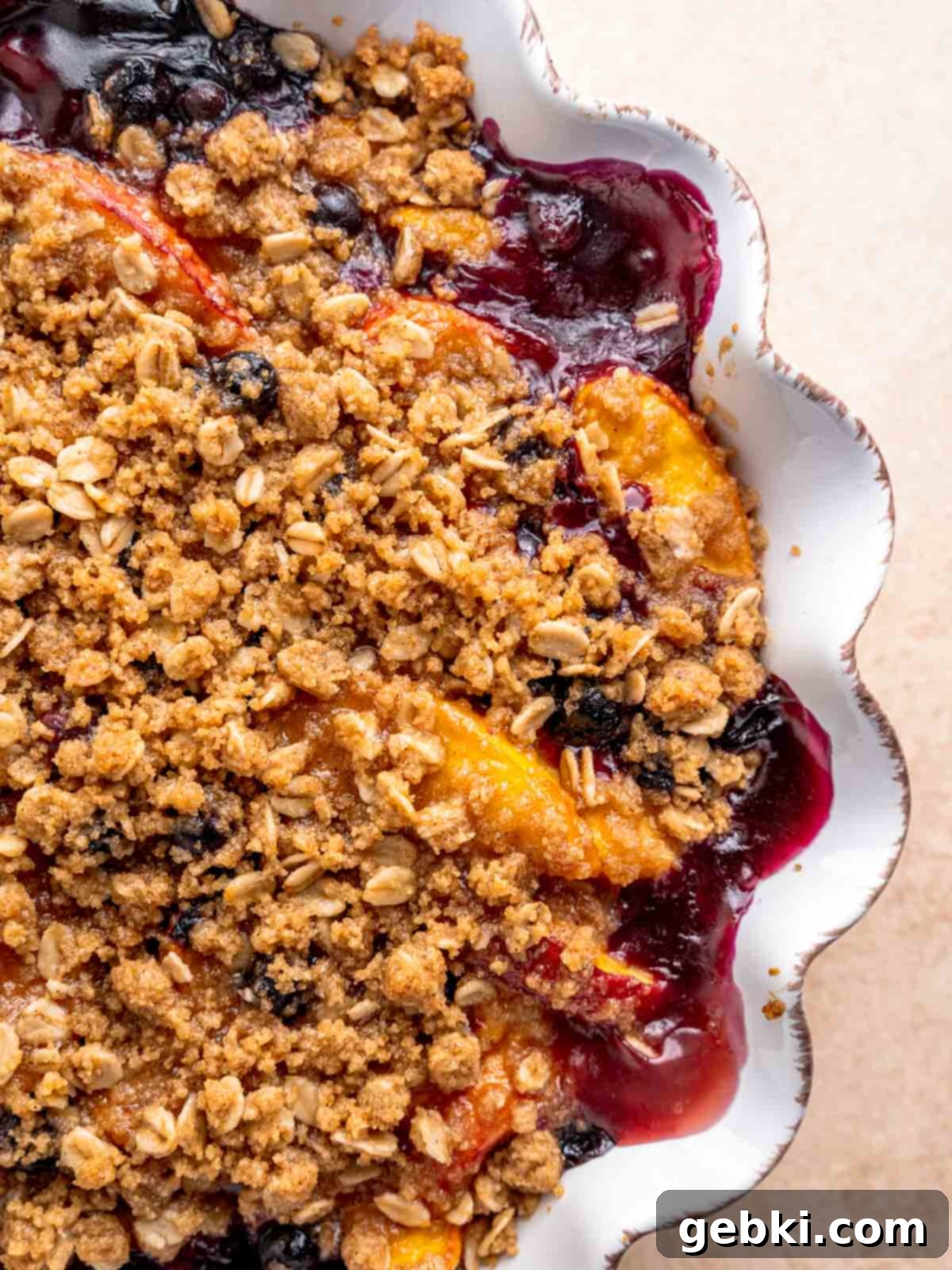 Sweet Summer Blueberry Peach Crisp 7 A beautifully baked blueberry peach crisp, golden brown and bubbling, fresh from the oven in a pie dish.