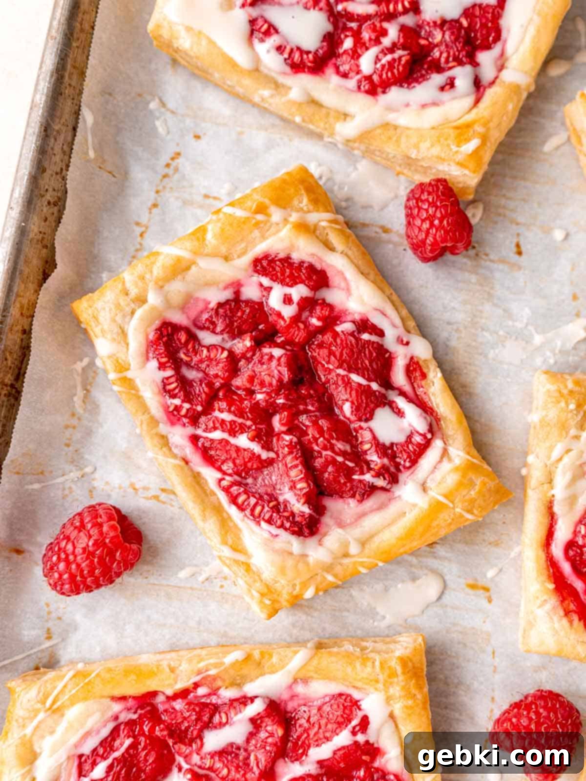 Easy Raspberry Cream Cheese Danish 2 Raspberry cream cheese danish on a baking sheet with parchment paper.