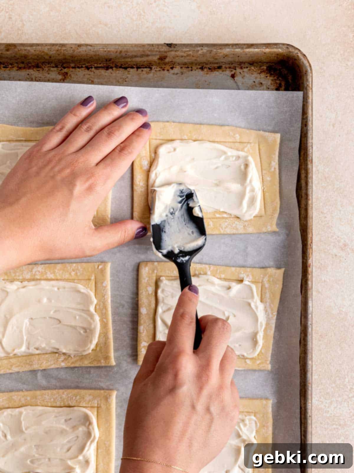 Easy Raspberry Cream Cheese Danish 7 Spreading cream cheese mixture onto puff pastry using a spatula.