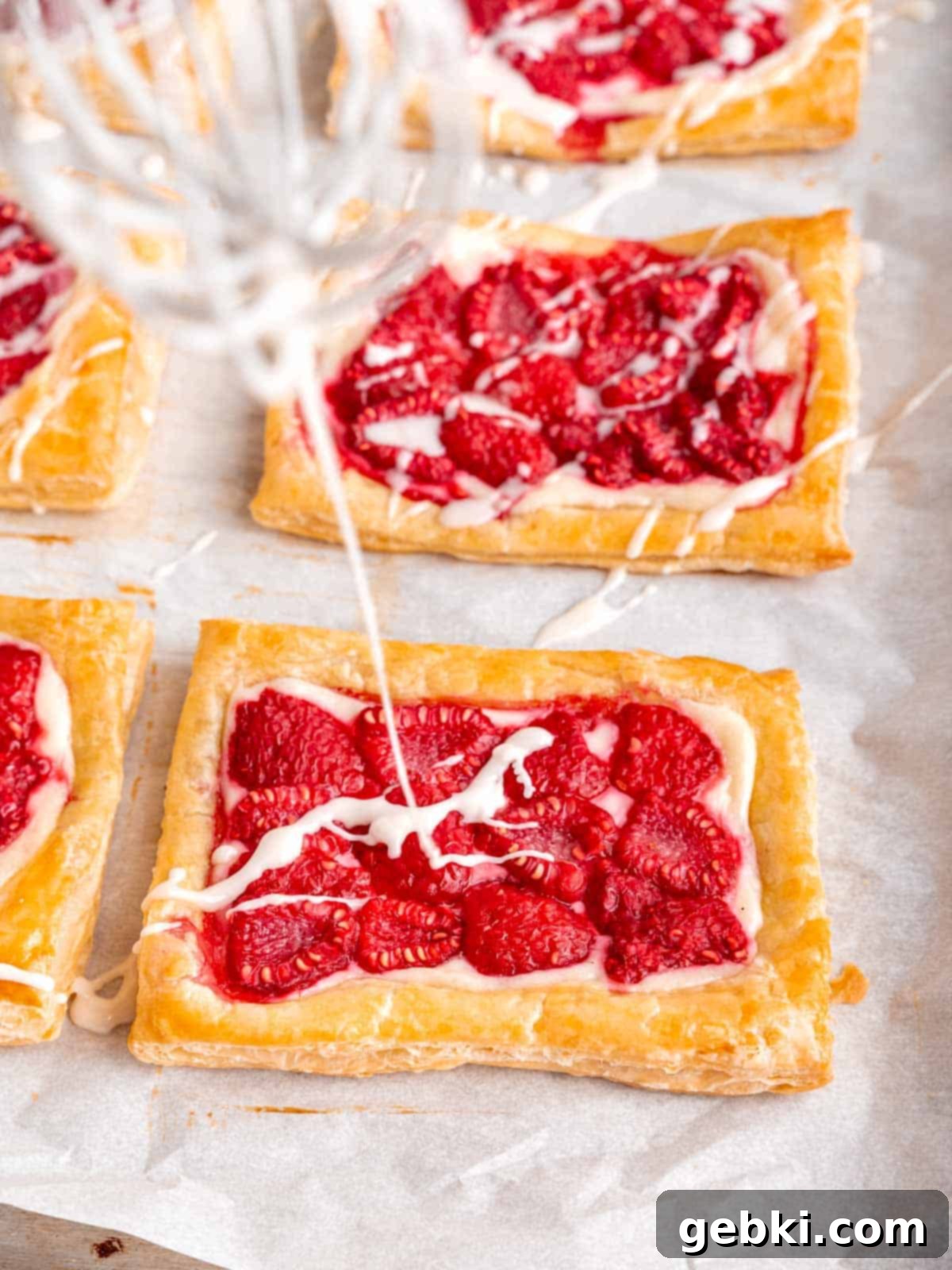 Easy Raspberry Cream Cheese Danish 9 Drizzling icing on a raspberry cream cheese danish.