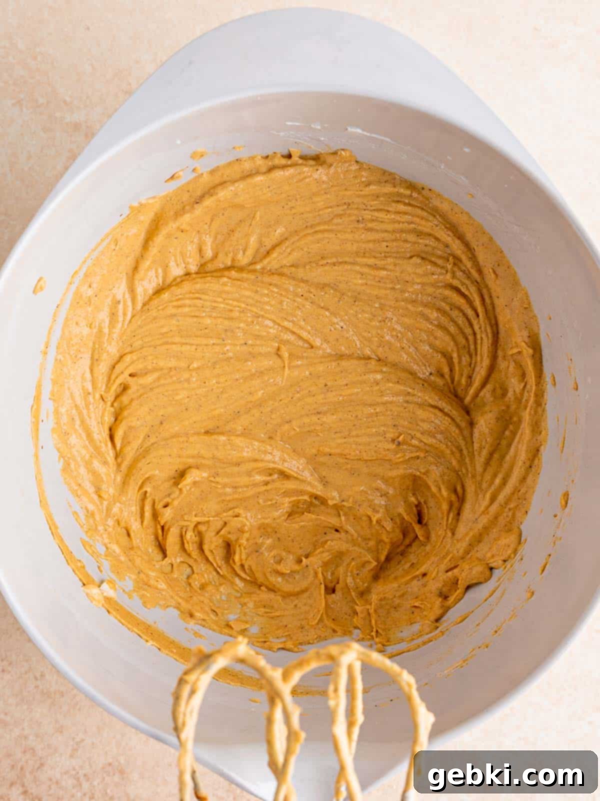 Pumpkin cheesecake mixture in a bowl, smooth and creamy.