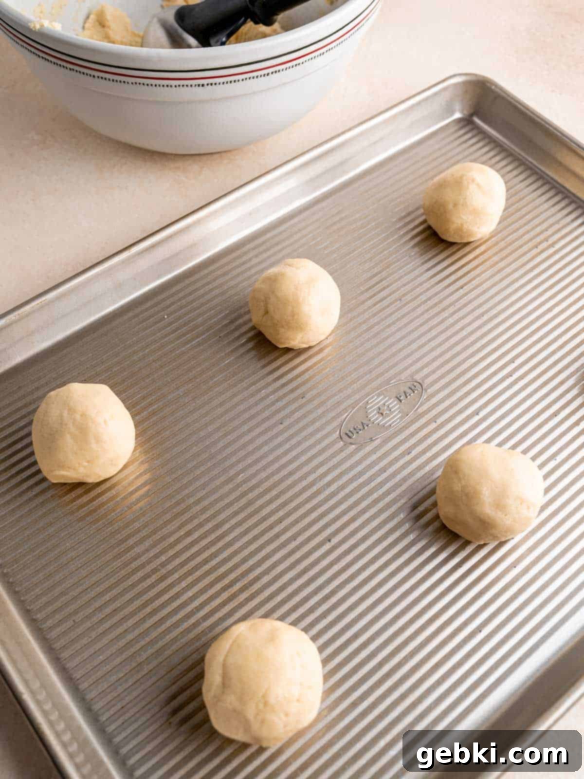 Velvet Almond Sugar Cookies 7 Almond sugar cookie dough balls on a baking sheet.