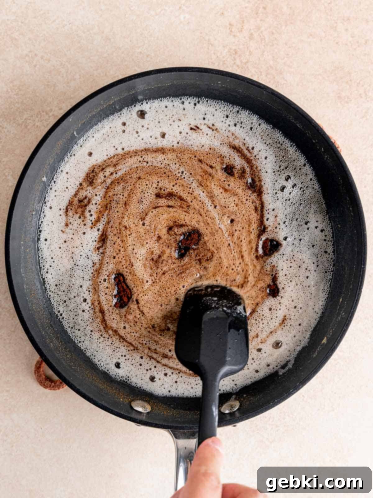 Espresso Sea Salt Chocolate Chip Cookies 4 Stirring espresso grounds into browned butter in a pan, showcasing the rich, nutty butter.