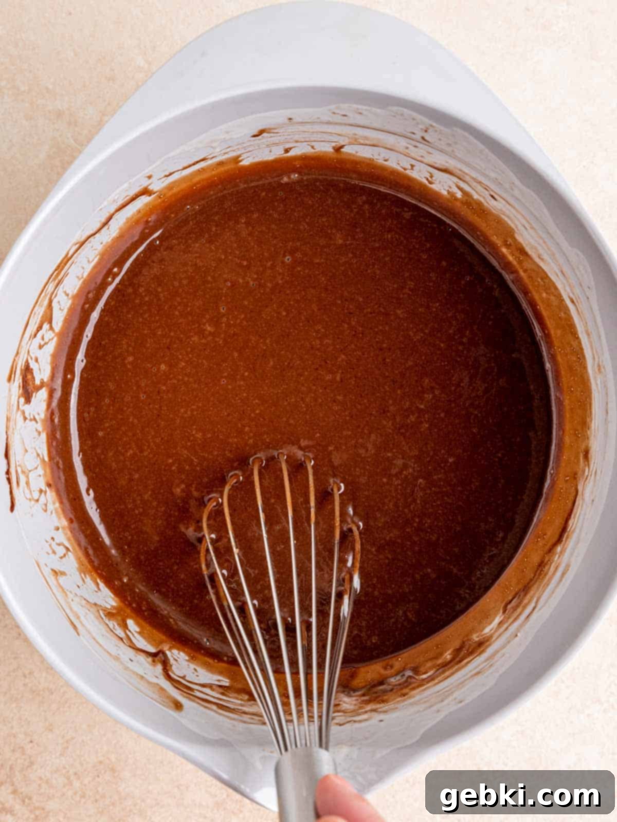 Ultimate Easy Triple Chocolate Brownie Muffins 5 Whisking together vegetable oil, sugars, melted chocolate, eggs, and kefir in a bowl.