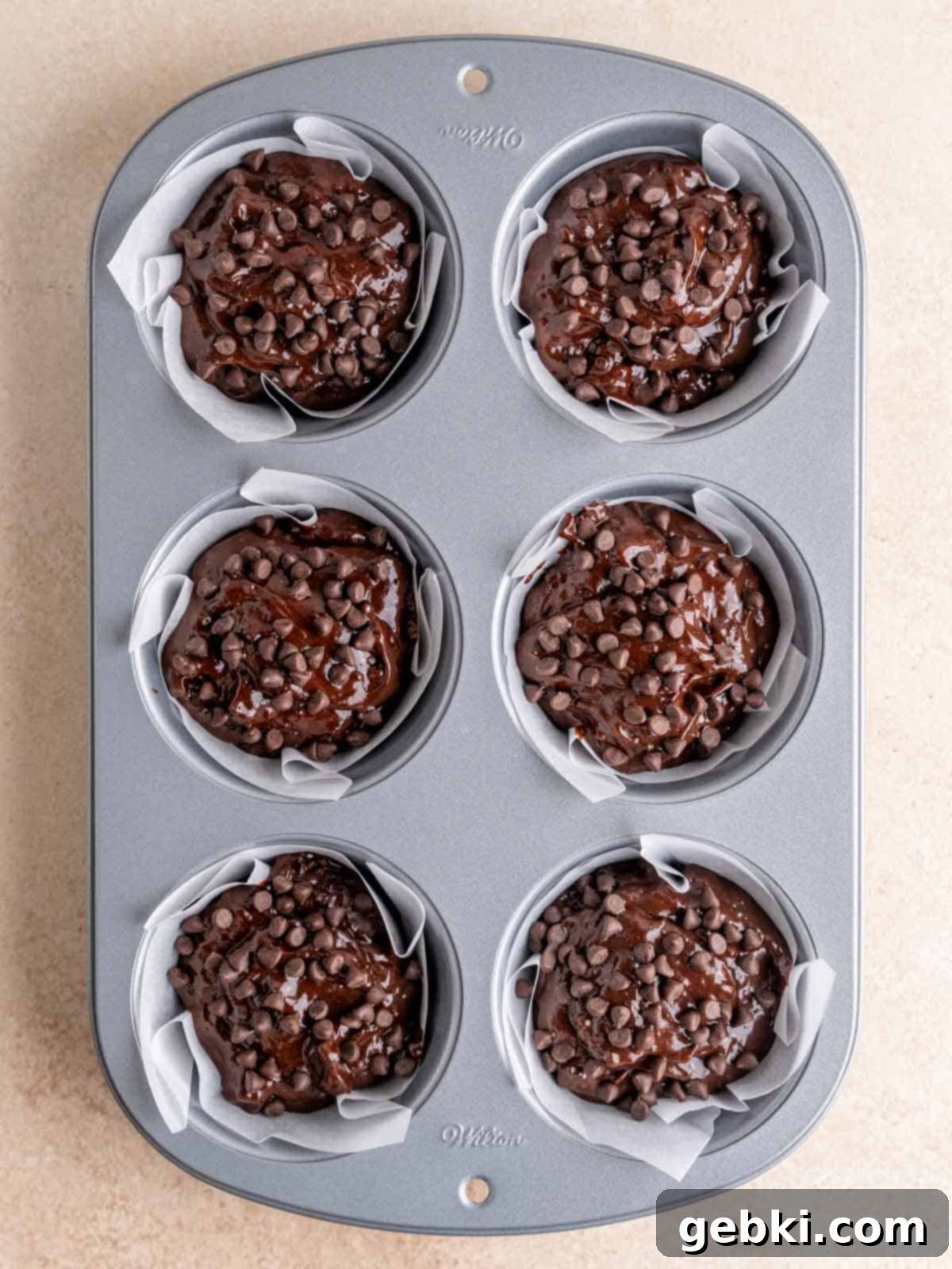 Ultimate Easy Triple Chocolate Brownie Muffins 7 A jumbo muffin pan filled with chocolate muffin batter.