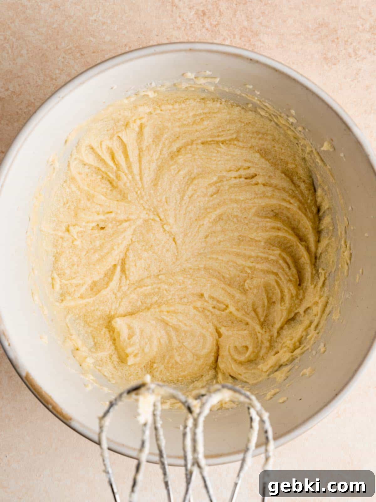Pillowy Soft Cut-Out Sugar Cookies 4 Creamed butter and sugar with egg, vanilla, and lemon extract in a mixing bowl, showcasing the fluffy texture of the wet ingredients.