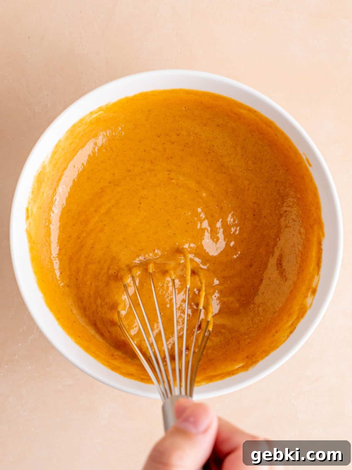 Whisking pumpkin pie filling in a small bowl.