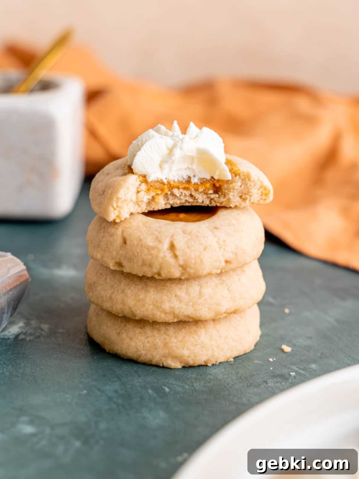 A stack of pumpkin pie thumbprint cookies.