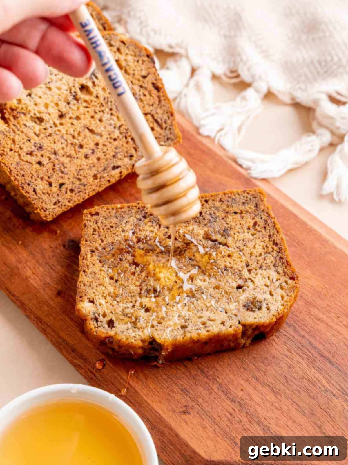 Golden Honey Banana Loaf 2 Drizzling honey on a slice of banana bread, highlighting its moist texture and golden crust.