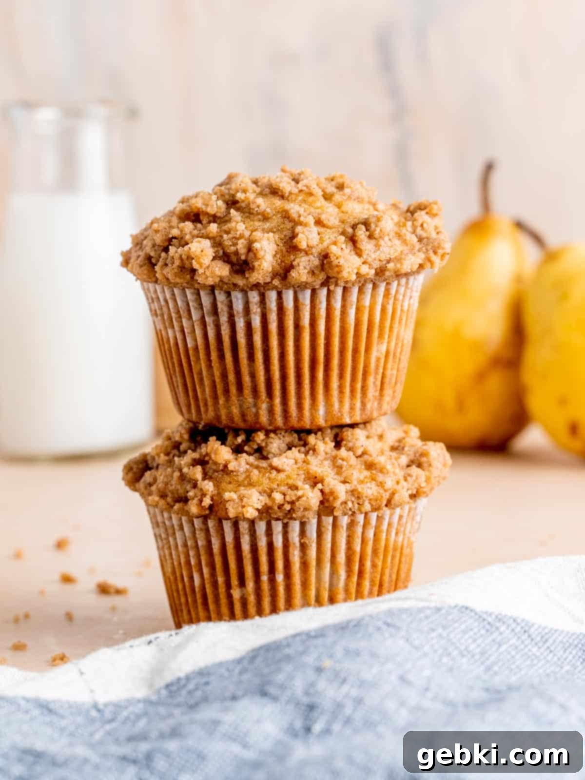 A stack of two honey pear muffins with cinnamon streusel.