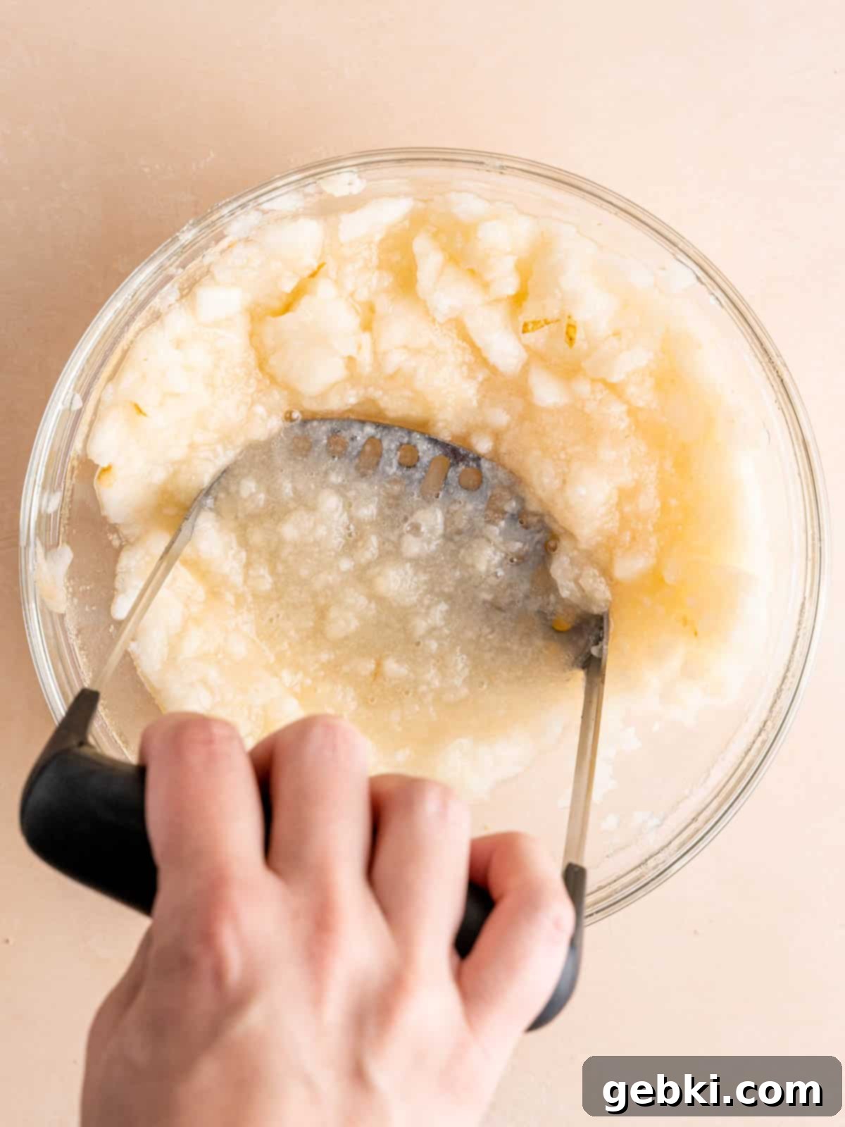 Mashing ripe pears in a bowl.