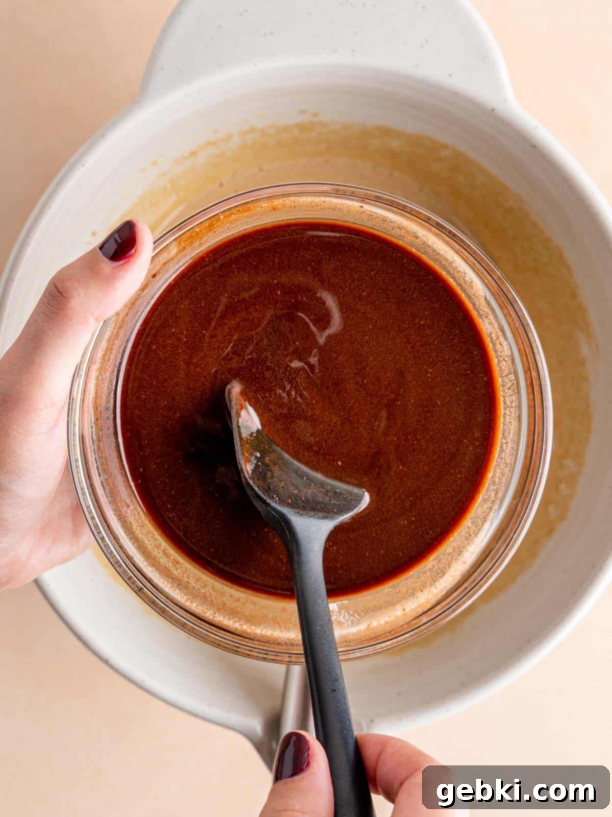 Effortless Fudgy Sourdough Discard Brownies 5 Stirring melted chocolate and butter in a bowl with a spatula, ensuring a smooth, glossy consistency.