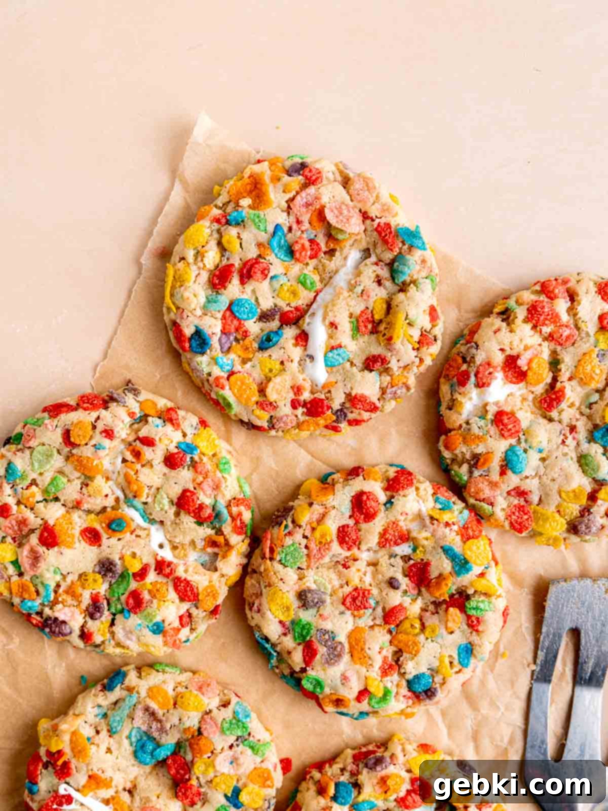 Fruity Pebble marshmallow cookies on a sheet of parchment paper.