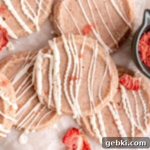 Effortless Strawberry Shortbread Cookies 11 Strawberry shortbread cookies with white chocolate drizzled on top, vibrant and tempting.
