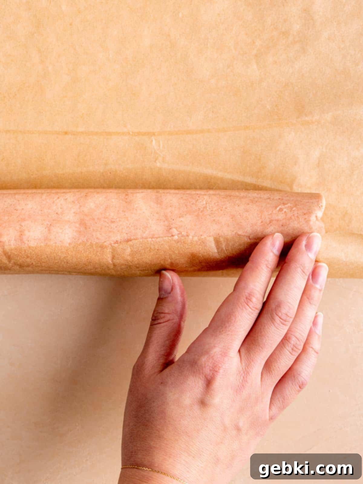 Effortless Strawberry Shortbread Cookies 6 A perfectly formed log of strawberry shortbread cookie dough resting on parchment paper.
