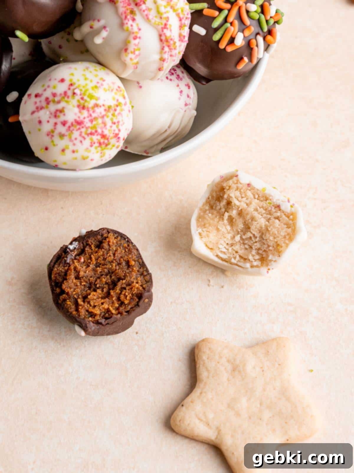No-Bake Christmas Cookie Truffles 13 A close-up shot of both gingerbread and sugar cookie truffles, some with bites taken out, showcasing their rich interior and perfectly set chocolate coating with festive sprinkles.