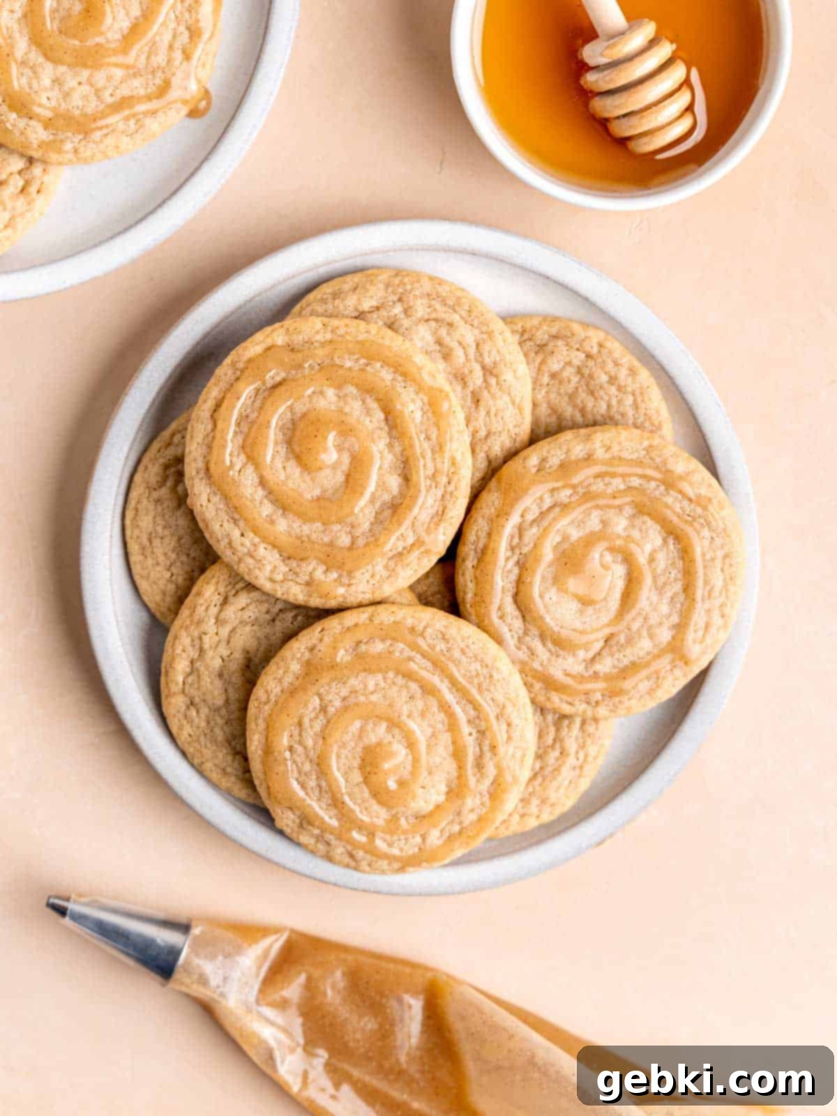 Glazed Honey Bun Cookies Made Easy 2 Honey bun cookies on a plate, featuring the iconic swirled glaze.