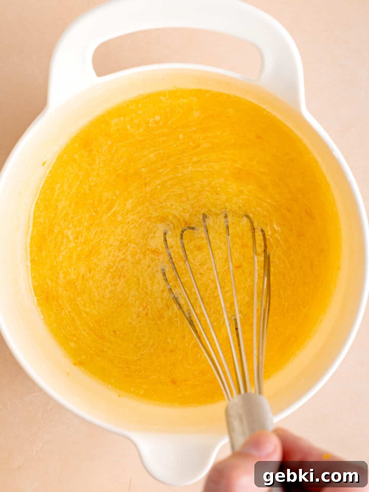 Zesty Orange Poppy Seed Muffins with Glaze 5 Whisking wet ingredients: eggs, vegetable oil, buttermilk, orange juice, and orange zest in a separate bowl.