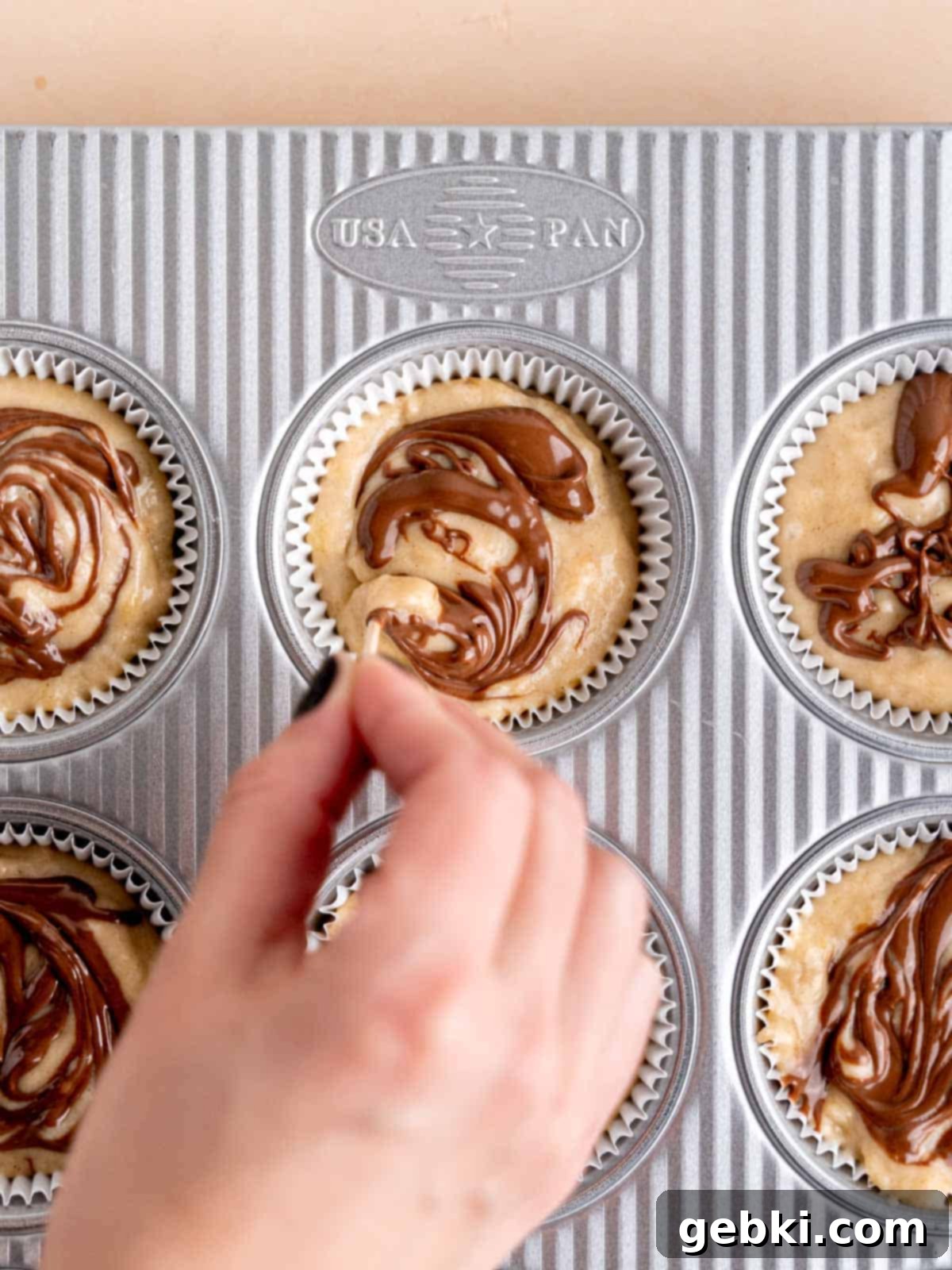 Marbleized Banana Nutella Muffins 8 Carefully swirling creamy Nutella onto the banana muffin batter in a muffin cup, creating a beautiful marbled effect and adding rich flavor.