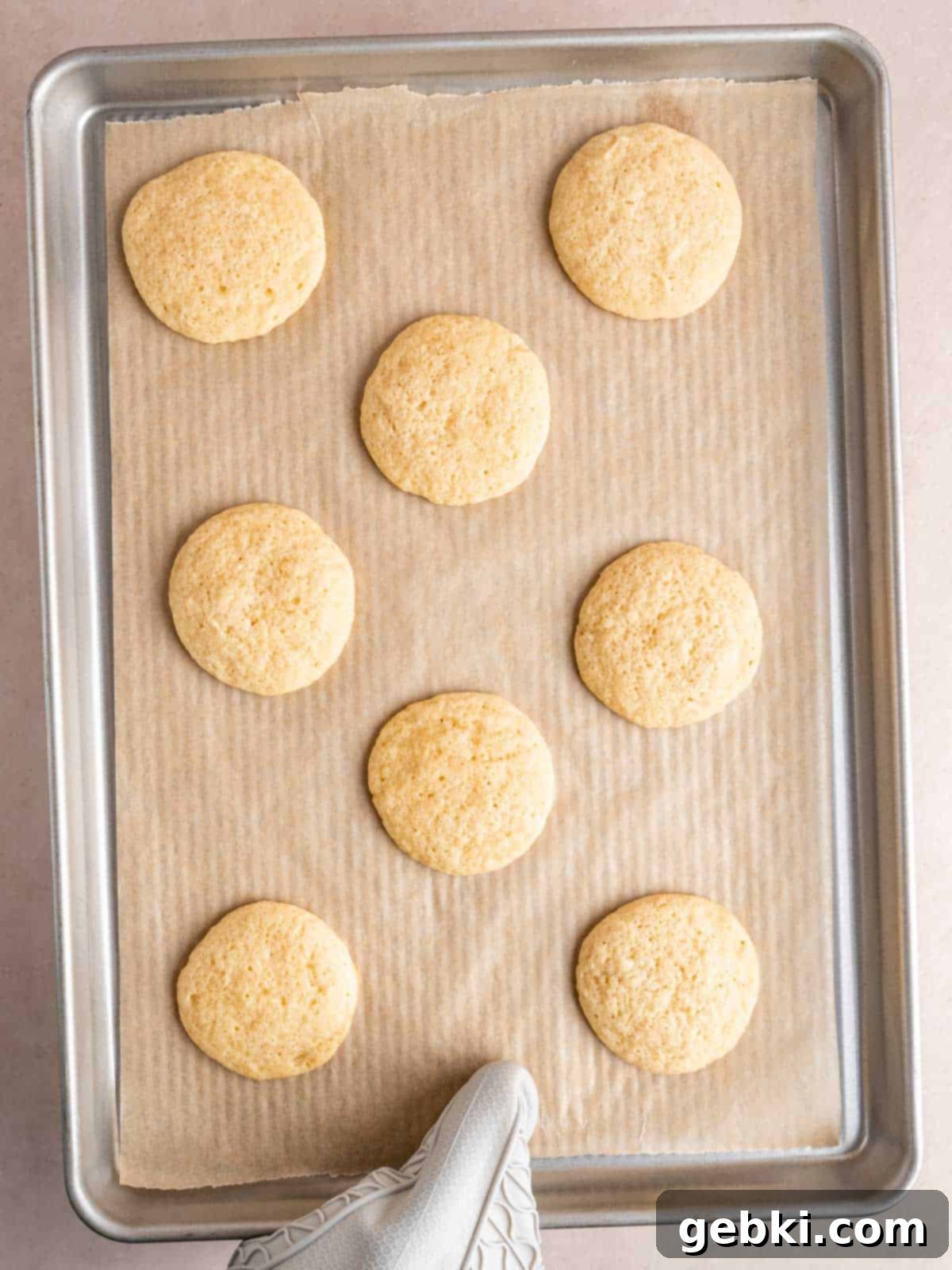 Pillowy Sour Cream Cookies with Sweet Frosting 7 Baked sour cream cookies on a baking pan.
