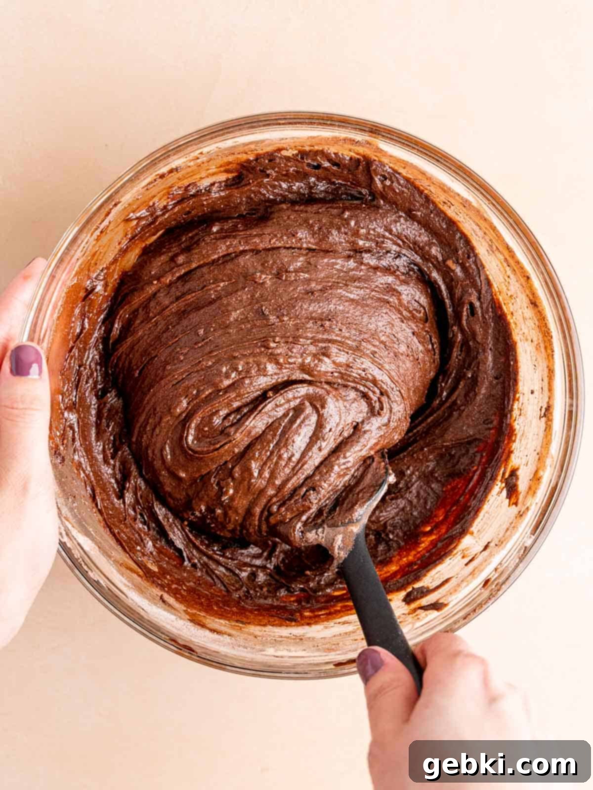Folding all-purpose flour, cocoa powder, and salt into the wet brownie batter.