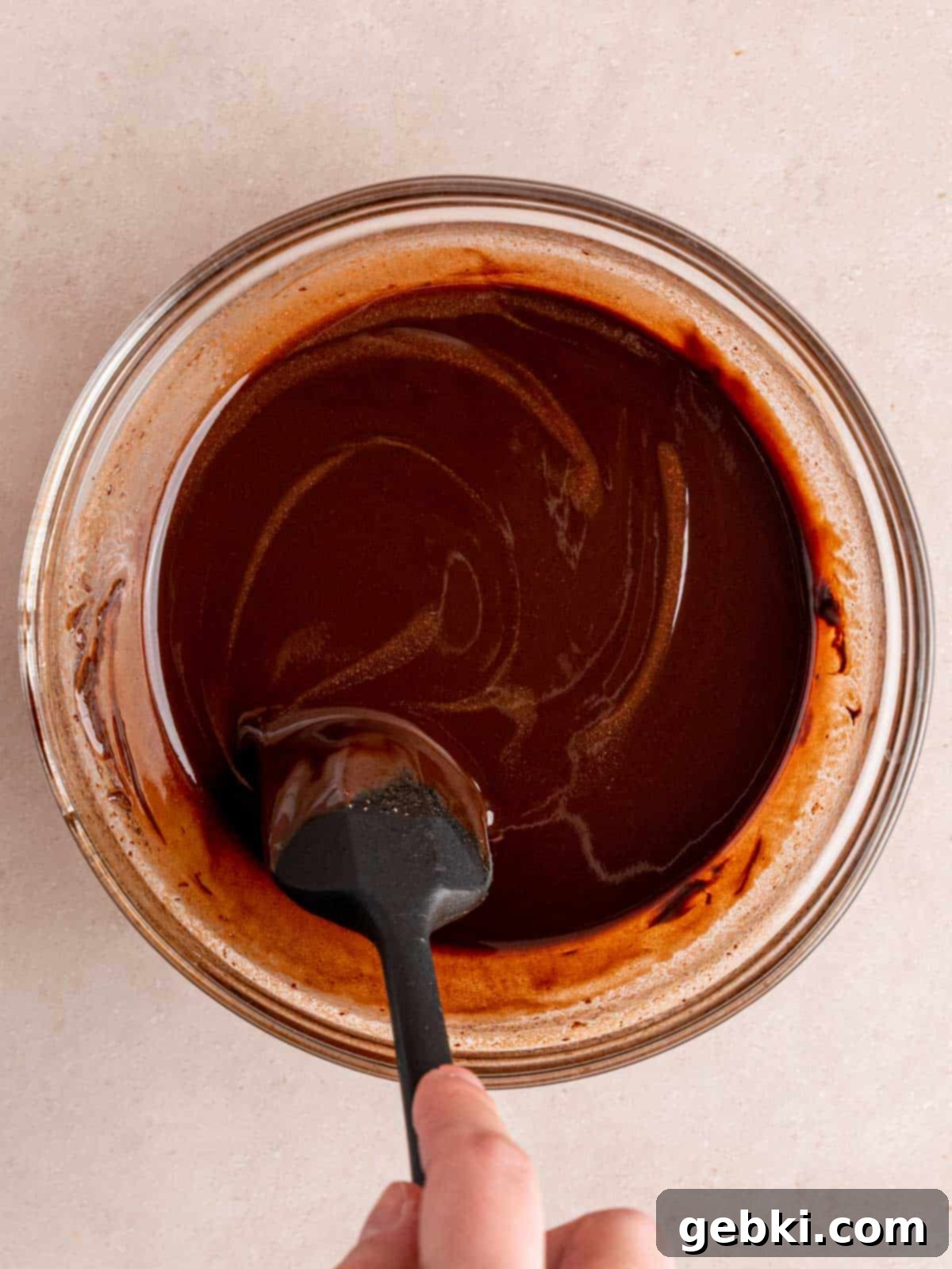 Decadent Raspberry Chocolate Fudge Brownies 4 Stirring melted chocolate and butter together in a mixing bowl until smooth and fully combined.