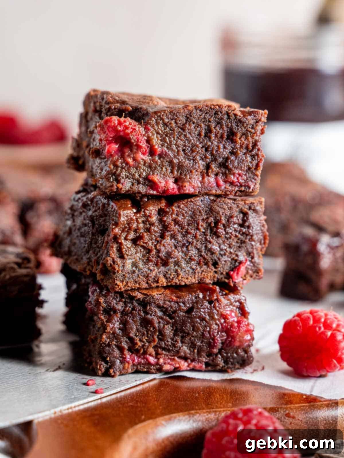 Decadent Raspberry Chocolate Fudge Brownies 10 A stack of thick, rich, fudgy chocolate raspberry brownies, highlighting their appealing texture and berry swirls.