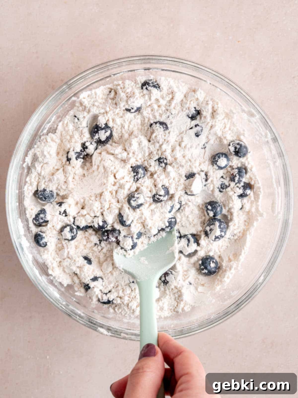 Irresistible Blueberry Sour Cream Coffee Cake 5 Mixing blueberries into a flour mixture.