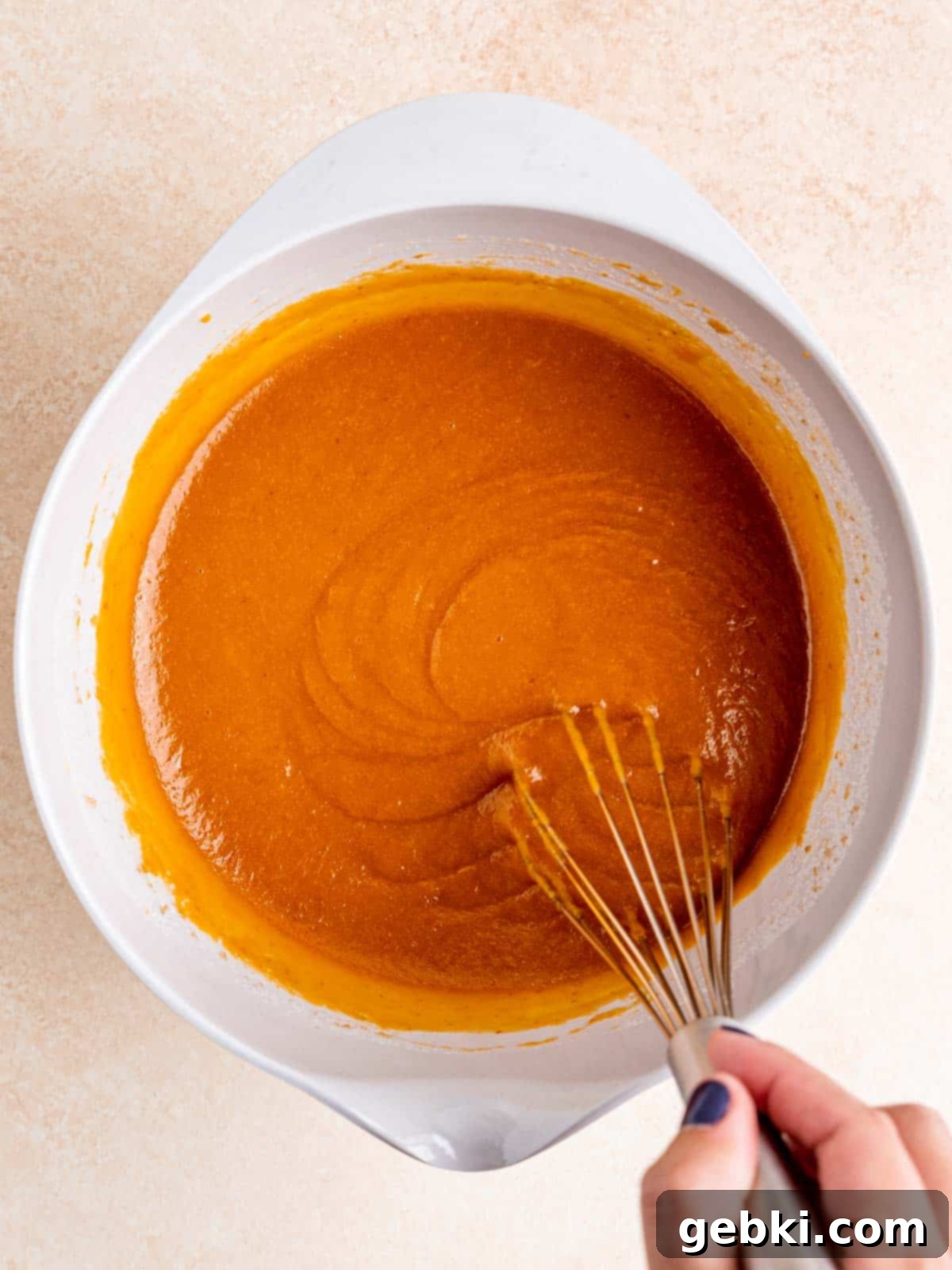 Snickerdoodle Swirl Pumpkin Bread 5 Whisking wet ingredients in a bowl: eggs, pumpkin puree, vegetable oil, granulated and light brown sugars, and vanilla extract.