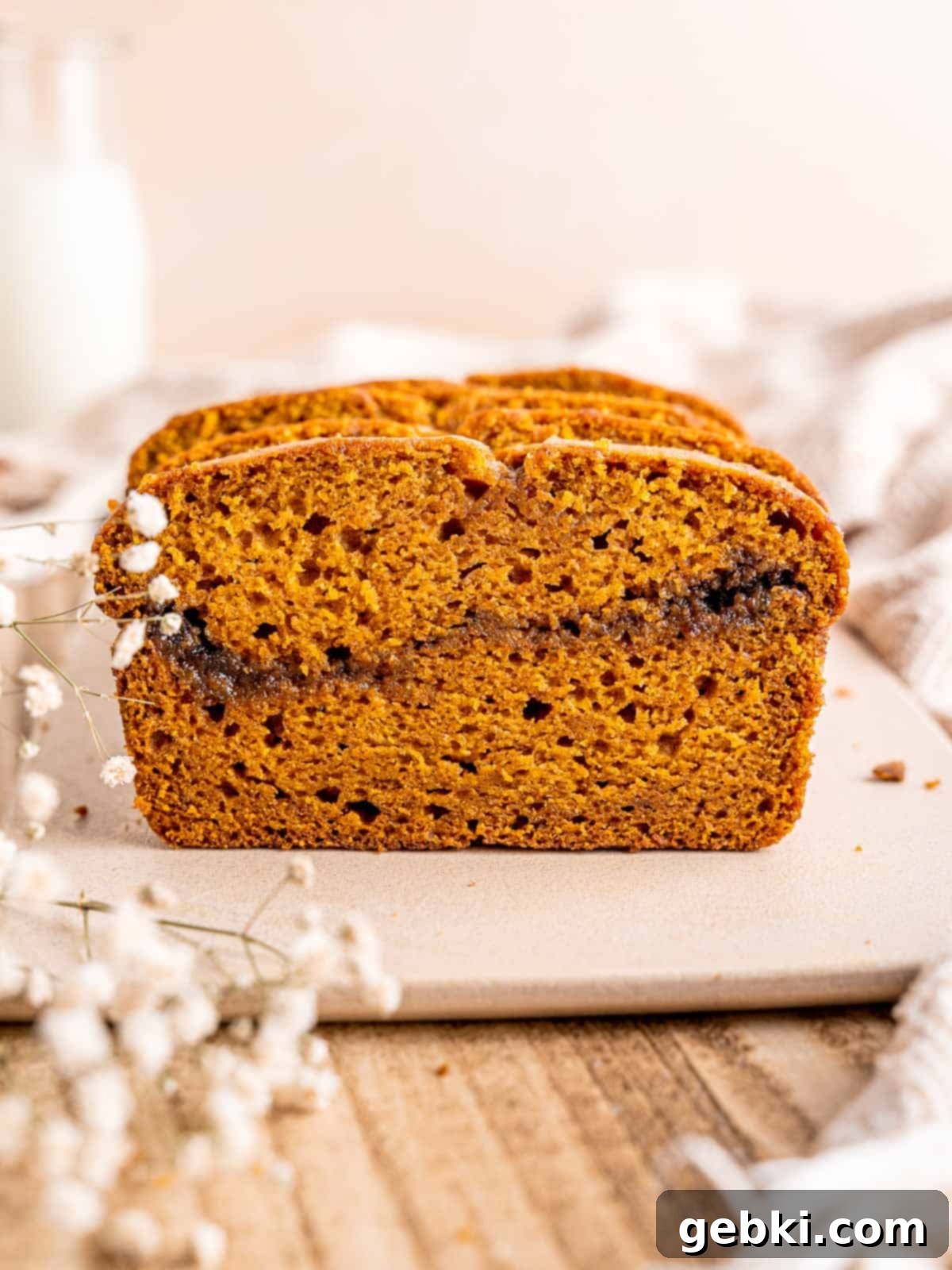 Snickerdoodle Swirl Pumpkin Bread 8 Pumpkin bread with a cinnamon sugar swirl in the middle, sliced and ready to serve.