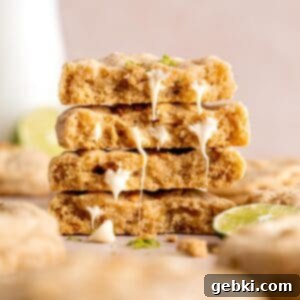 Zesty Key Lime White Chocolate Chip Cookies 9 A stack of white chocolate chip key lime cookies, garnished with extra white chocolate chips and graham cracker crumbs, showcasing their vibrant green hue and chewy texture.